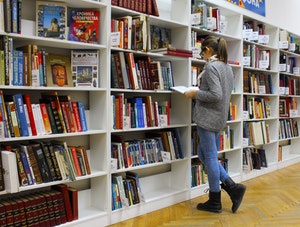 Girl looking at books on shelves 